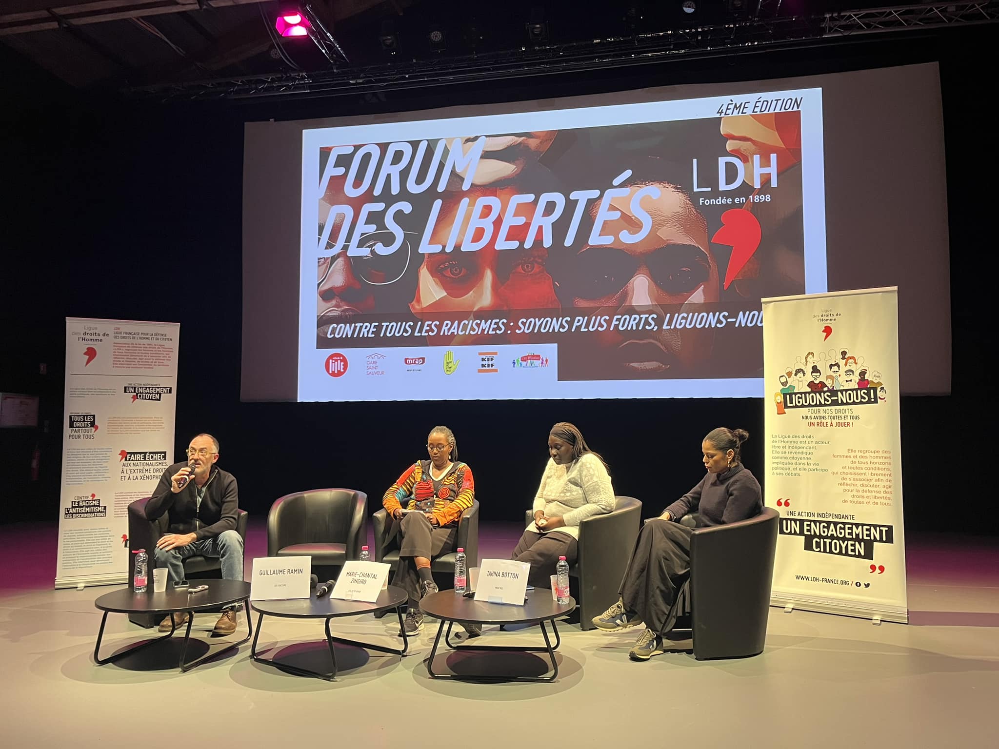 Des personnes assises dans des fauteuils sur une scène, pendant le Forum des Libertés 2024